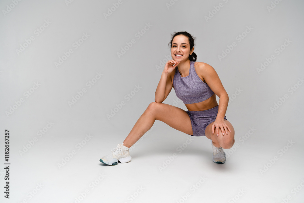 Fototapeta premium Strong sporty young woman athlete fitness gym trainer instructor coach in tracksuit sportswear resting practicing posing on white background. Sportive fit body building healthy lifestyle concept.