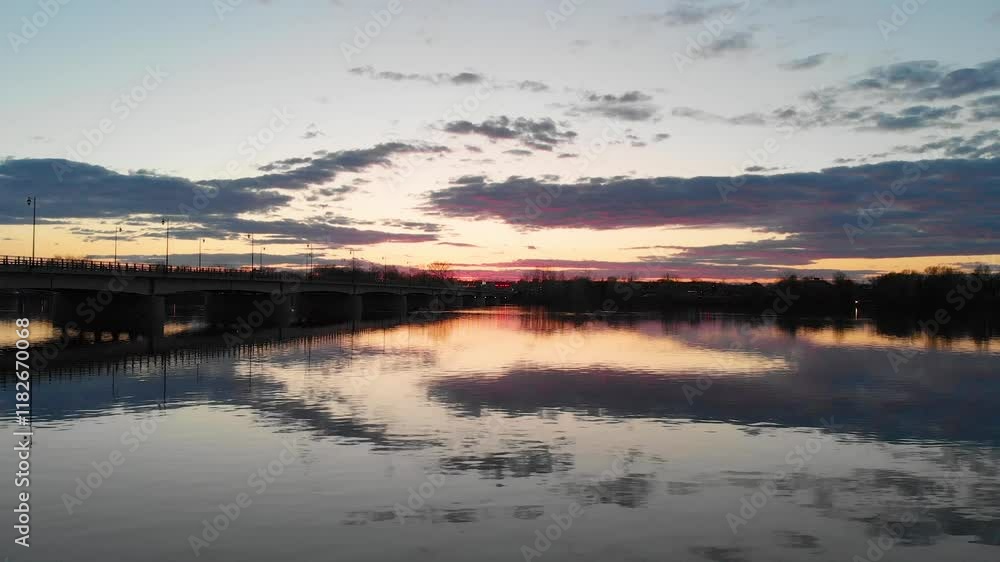 Drone flight over a water mirror at sunset in a summer in Canada over a bridge that connects two towns in a magical sunset Drone flight over a water mirror at sunset in a summer in Canada over a bridge that connects two towns in a magical sunset