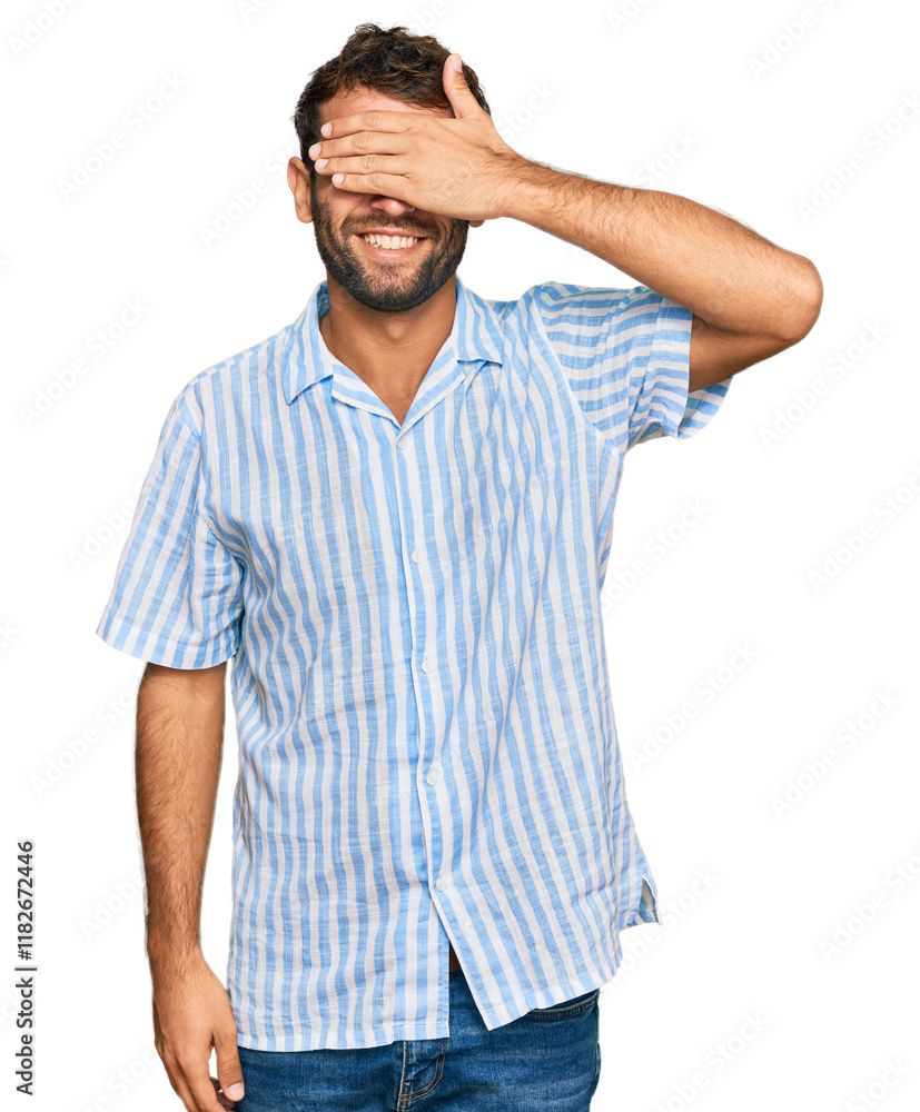 Handsome young man with beard wearing casual fresh shirt smiling and laughing with hand on face covering eyes for surprise. blind concept. Handsome young man with beard wearing casual fresh shirt smiling and laughing with hand on face covering eyes for surprise. blind concept.