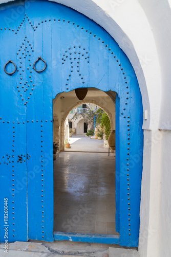 Djerba, Medenine, Tunisia. Small entry in a blue Moorish arch door. photo