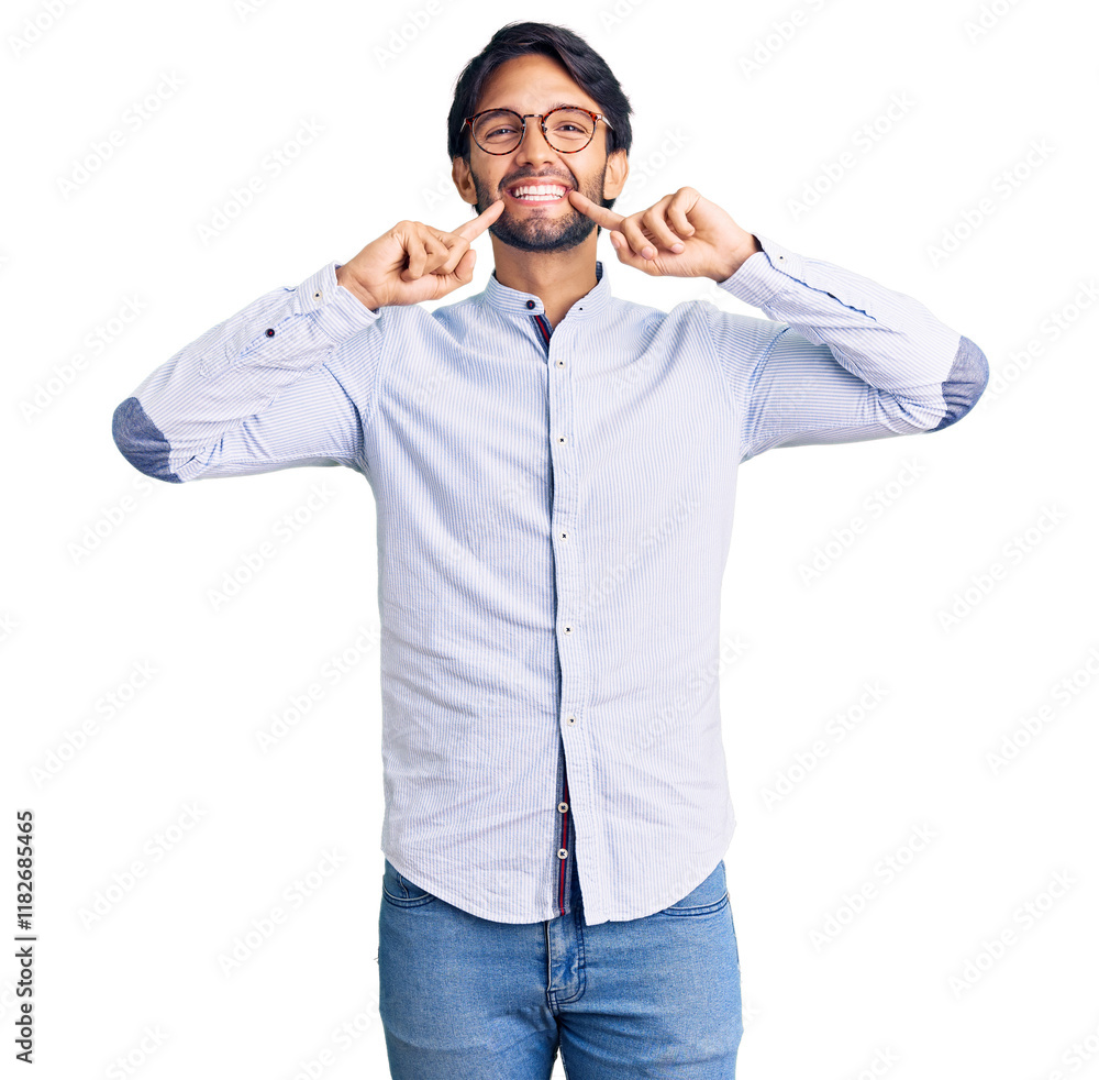 Fototapeta premium Handsome hispanic man wearing business shirt and glasses smiling with open mouth, fingers pointing and forcing cheerful smile
