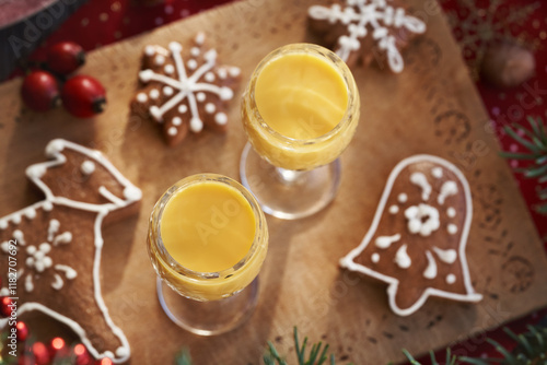 Two glasses of Eiecognac on a wooden table with decorated gingerbread Christmas cookies photo