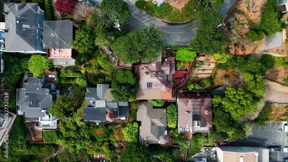 Tomas aéreas en la mañana: El dron sobrevuela un vecindario residencial en San Francisco durante la calma matutina, capturando casas con tejados inclinados y calles inclinadas que reflejan la geografí
