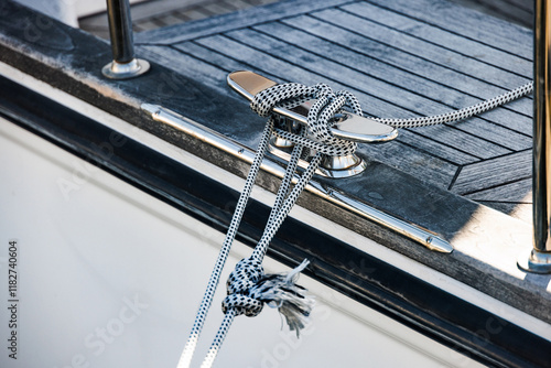 Cleat hitch securing rope on modern sailboat deck photo