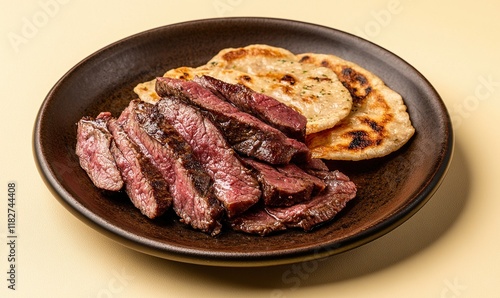 Delicious basturma served on a smooth brown plate with Armenian flatbread and a light yellow background photo