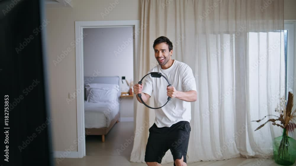 Man exercising pilates ring at lively sport session home. Smiling guy stretching Man exercising pilates ring at lively sport session home. Smiling guy stretching
