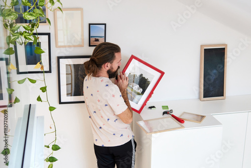 Man decorates his apartment with pictures photo