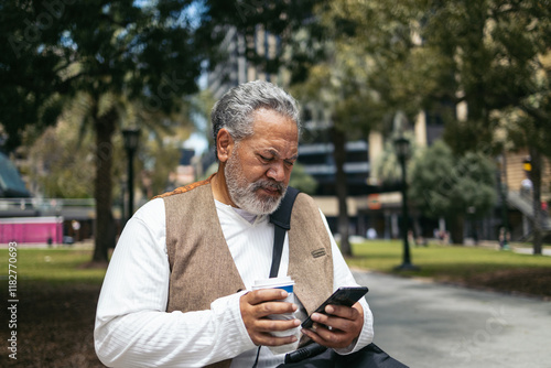 Man using smartphone outdoors during break photo