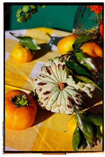 Autumn harvest display featuring persimmon and citrus fruits on table photo