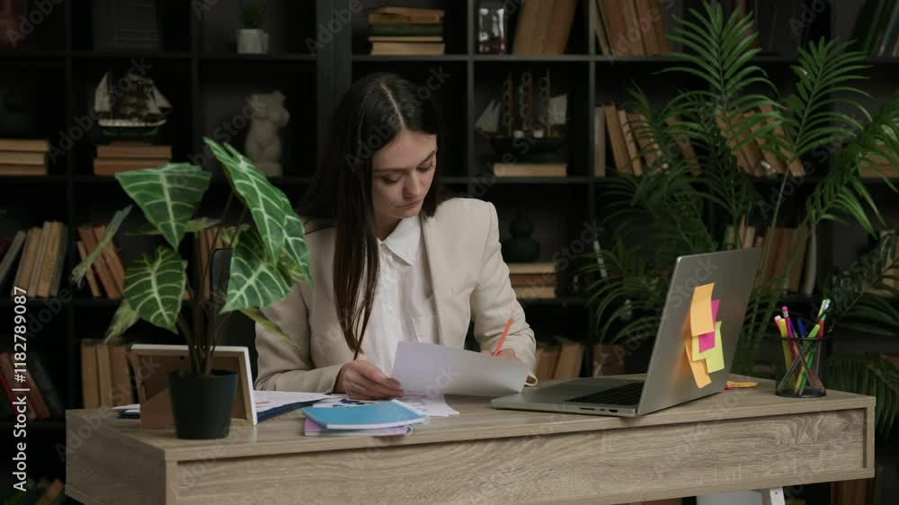 Female IT programmer analyzes a task she has to complete. Woman in classic suit at work in a modern and comfortable office thinks about how to complete a complicated program Female IT programmer analyzes a task she has to complete. Woman in classic suit at work in a modern and comfortable office thinks about how to complete a complicated program