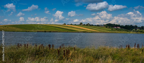 A panoramic view across the reservoir to the shore opposite, rolling fields w...