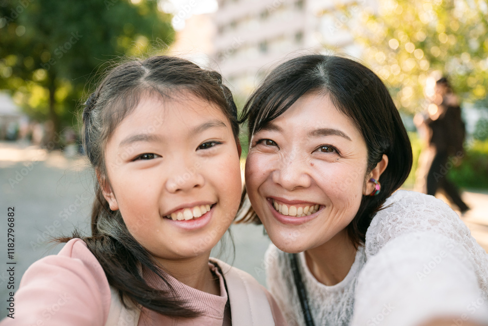 Happy mother and daughter taking a selfie in a park in Tokyo Japan Happy mother and daughter taking a selfie in a park in Tokyo Japan
