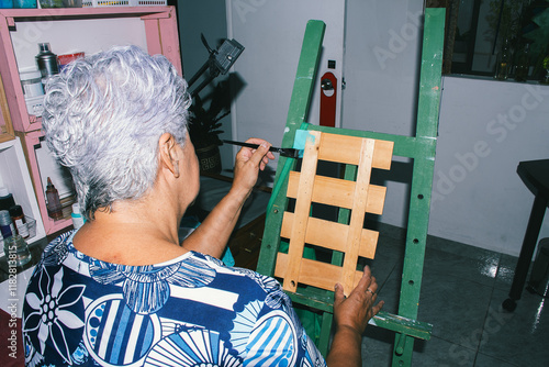 Elderly woman painting in her art studio photo