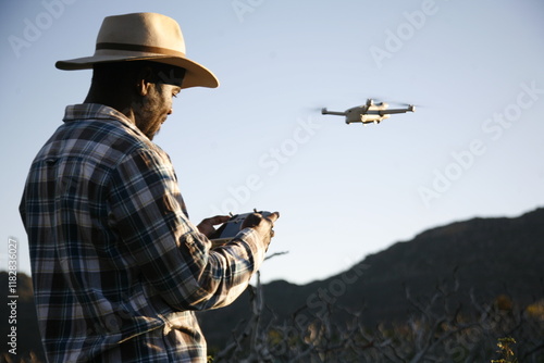 A drone pilot conducts a photograph survey of a farm. photo