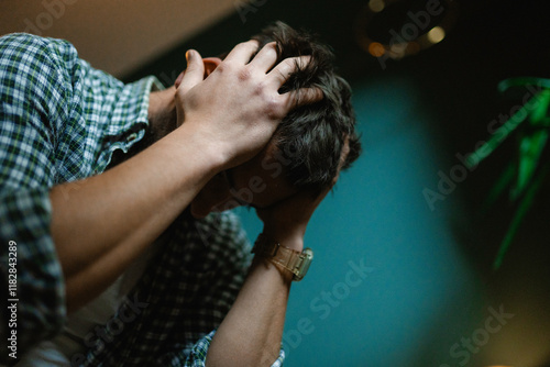 A man holds his head while sitting on the bed photo