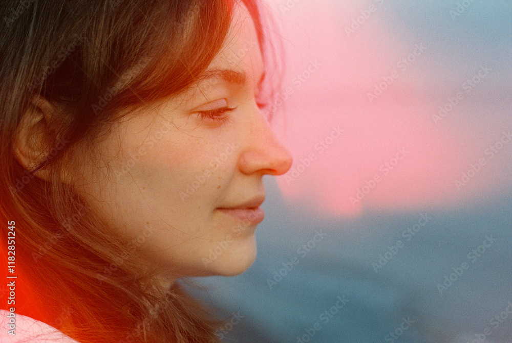 Side profile of a woman with soft smile on her face Side profile of a woman with soft smile on her face