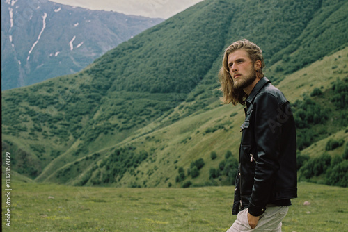 A handsome man standing among the mountain peaks photo