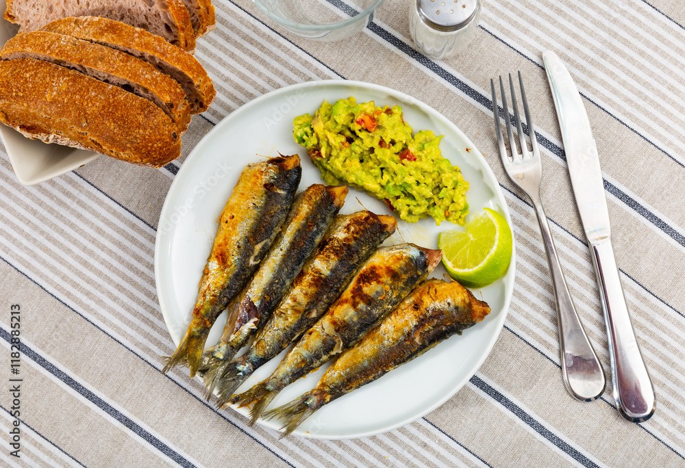 Delicious grilled sardines with guacamole and lemon Delicious grilled sardines with guacamole and lemon