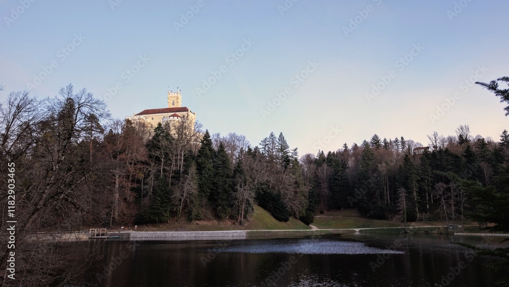 Beautiful winter scenery of Trakošćan Castle on the hill by the lake in the forest at Croatia, county hrvatsko zagorje, nature background