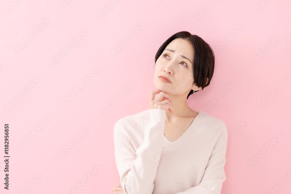 悩む・考える・困る女性・ピンクバック 悩む・考える・困る女性・ピンクバック