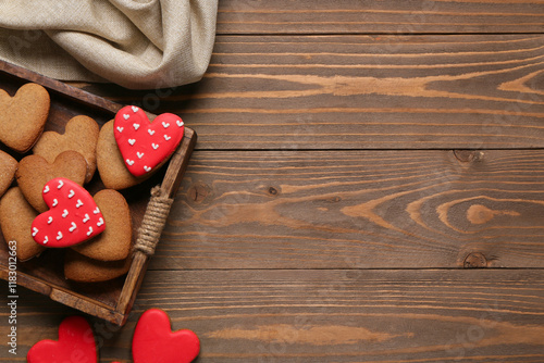 Tray with tasty heart shaped cookies and tablecloth on wooden background. Valentine's Day celebration