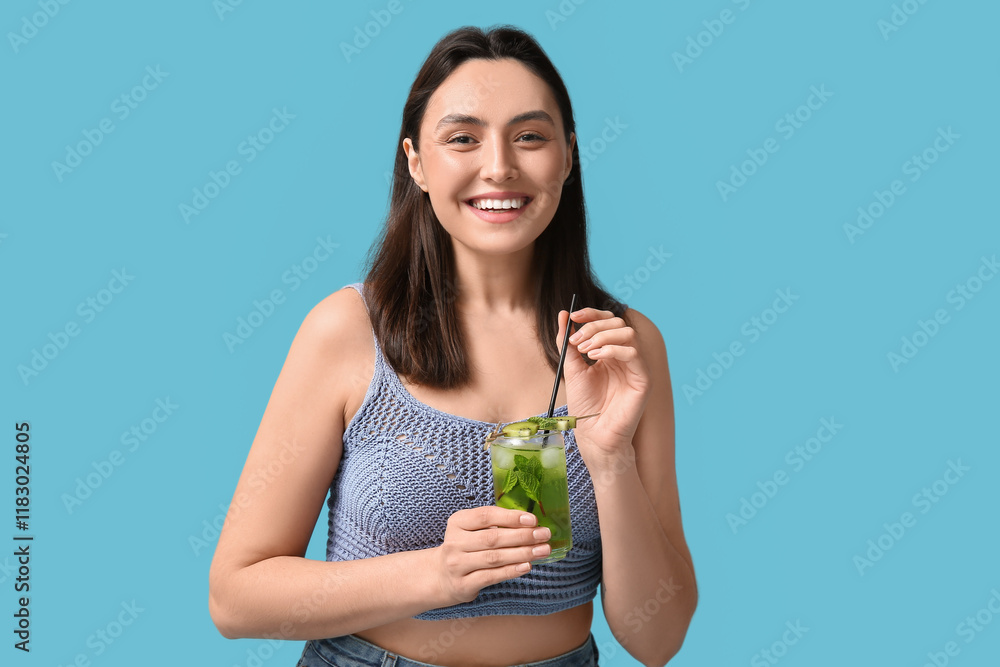 Beautiful young woman holding glass of tasty cocktail with kiwi on blue background Beautiful young woman holding glass of tasty cocktail with kiwi on blue background