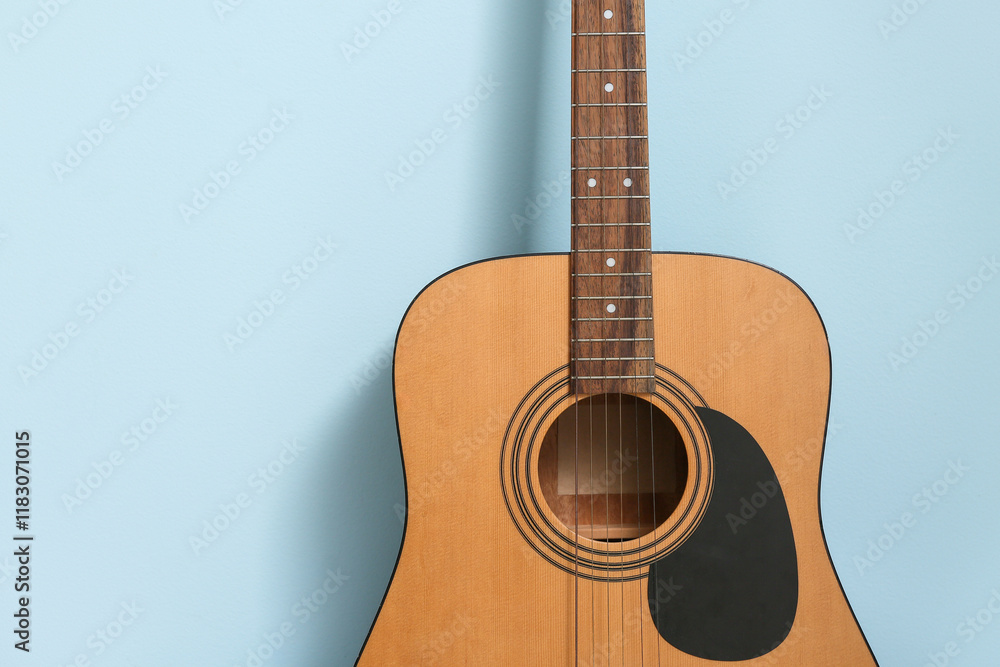 Obraz premium Acoustic guitar near color wall, closeup