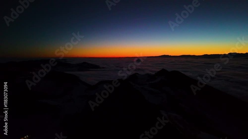 First colours of the last sunrise of the year 2024. View on the east part of Swiss Alps. Central Switzerland hiding under beautiful cover of clouds.