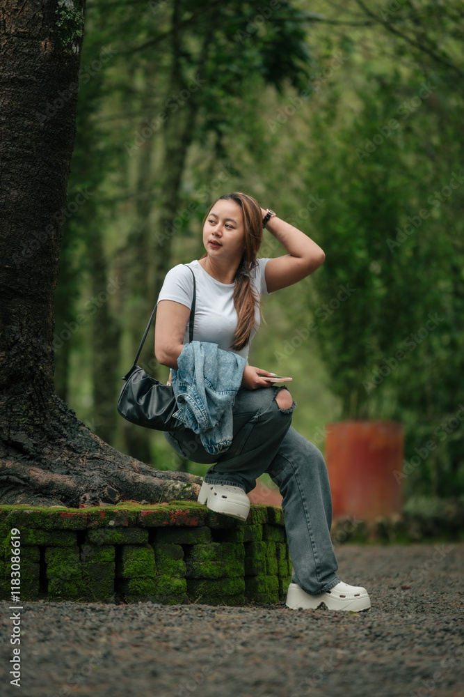 Naklejka premium Happy Woman in Casual Outfit Enjoying a Peaceful Forest Setting Outdoors