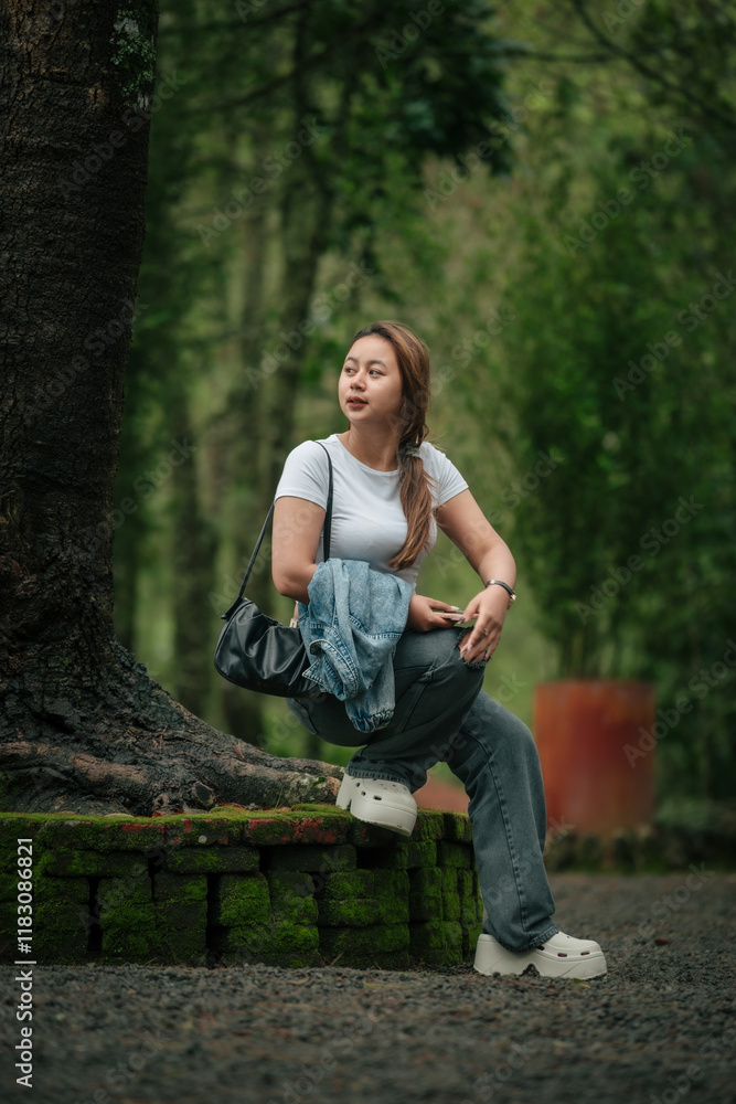 Obraz premium Happy Woman in Casual Outfit Enjoying a Peaceful Forest Setting Outdoors