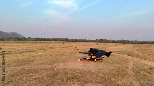 Untitled PrAn old pickup truck with a tent for sleeping on the roof is parked on a lawn during winter.oject photo