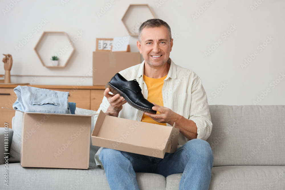 Mature man unpacking box with shoes at home Mature man unpacking box with shoes at home