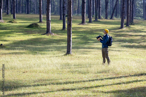 Photographer taking photo of the new discovering bird species while exploring in the pine forest for surveying and locating rare biological diversity and ecologist on field study photo