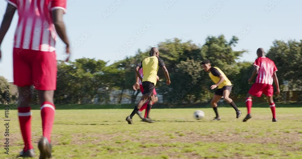 Playing soccer, male players tackling and competing for ball on field Playing soccer, male players tackling and competing for ball on field