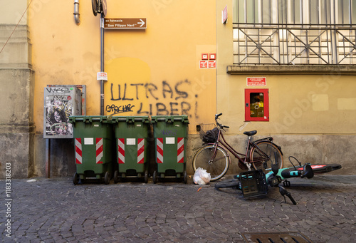 Fototapeta Naklejka Na Ścianę i Meble -  Urban decay in Parma city center, alley full of trash bags, waste, poor street cleanliness, signs of neglect