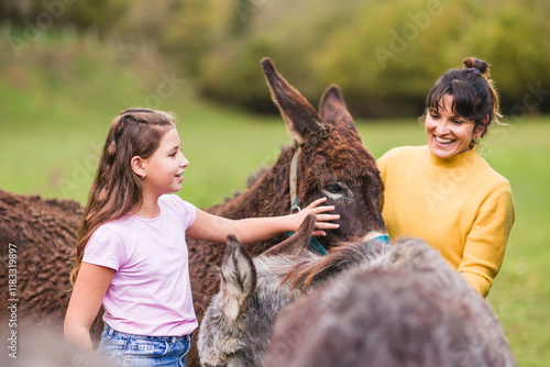 Girl and veterinarian caring for donkeys in animal sanctuary in quiros, asturias, spain photo