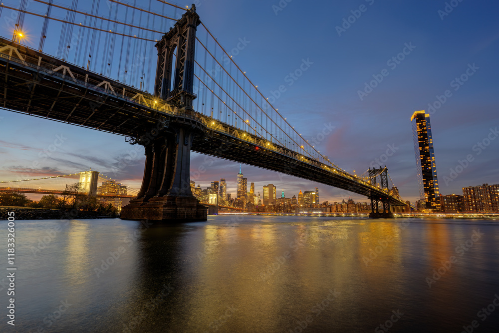 Naklejka premium The Manhattan Bridge in New York at dusk with the Brooklyn Bridge in the back