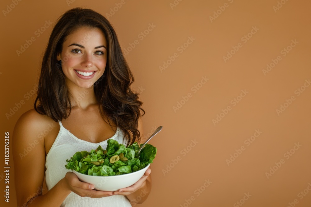 portrait of beautiful woman in sportswear eats fresh salad with vegetables on beige background portrait of beautiful woman in sportswear eats fresh salad with vegetables on beige background