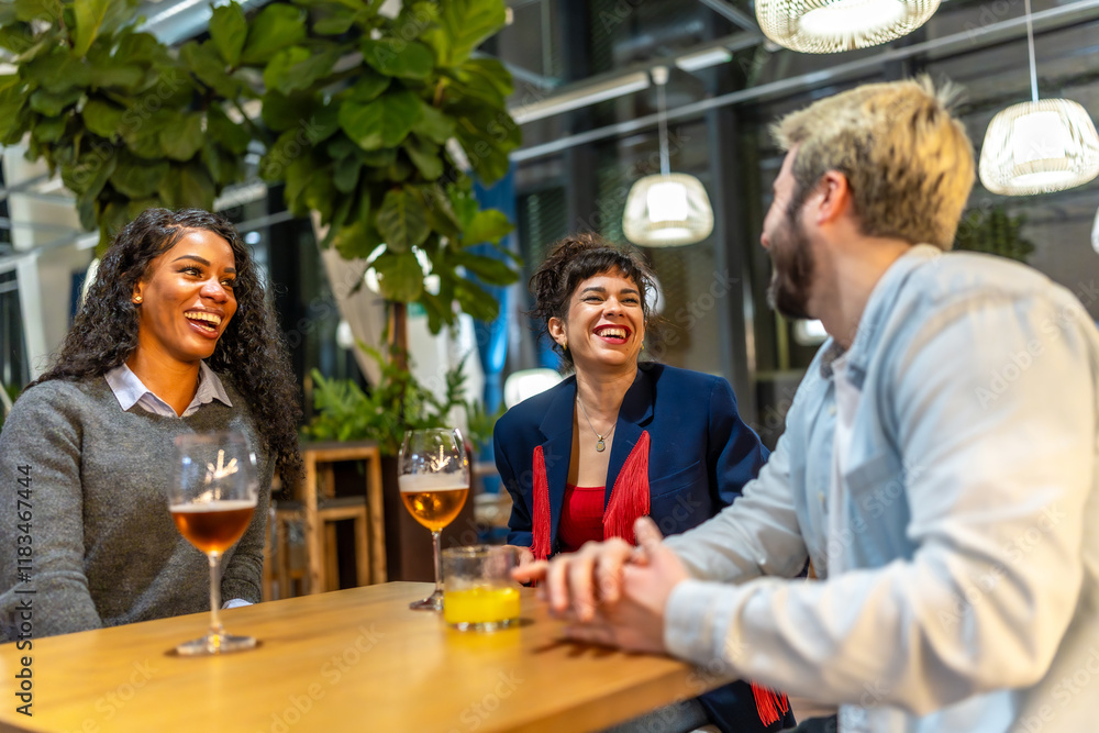 Friends laughing while talking in a night bar terrace