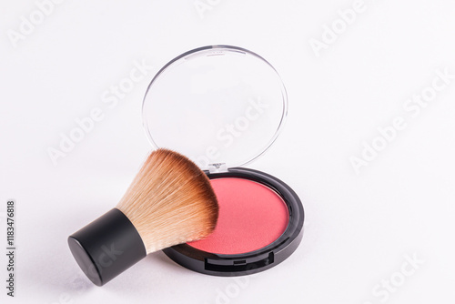 Foto An open round pack of compact blush in a pink tone with a professional fluffy short makeup brush