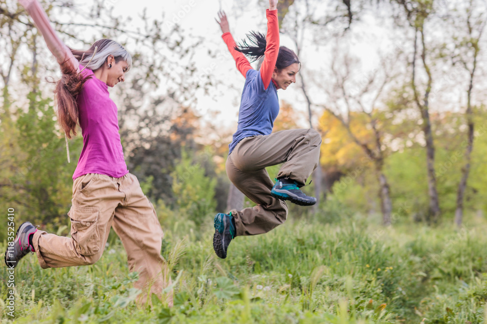 Hikers jumping in the forest, enjoying nature and friendship Hikers jumping in the forest, enjoying nature and friendship