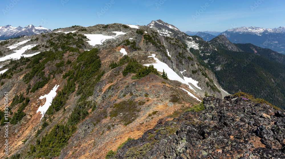 Scenic landscape of rocky mountain ridge top and snow capped peaks Scenic landscape of rocky mountain ridge top and snow capped peaks
