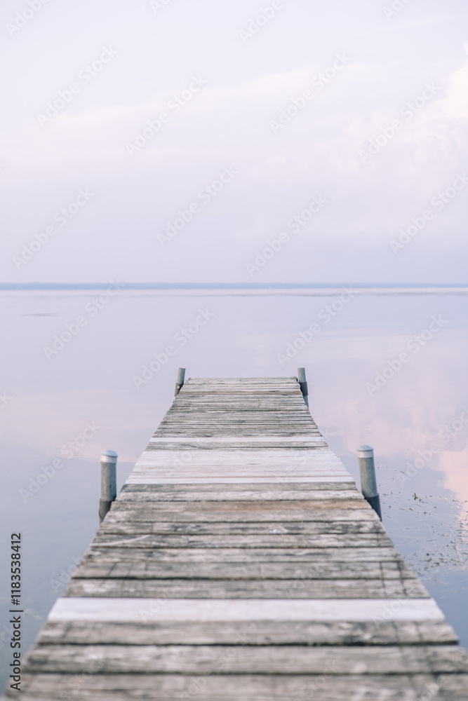 Obraz premium A peaceful sunset on a dock of Oneida Lake in summer.