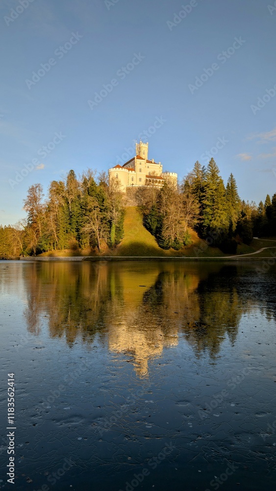 Beautiful winter scenery of Trakošćan Castle on the hill by the lake in the forest at Croatia, county hrvatsko zagorje, nature background