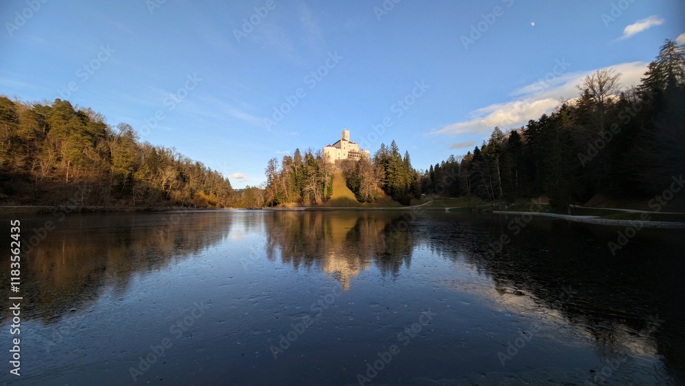 Beautiful winter scenery of Trakošćan Castle on the hill by the lake in the forest at Croatia, county hrvatsko zagorje, nature background