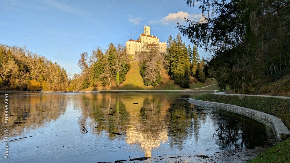 Beautiful winter scenery of Trakošćan Castle on the hill by the lake in the forest at Croatia, county hrvatsko zagorje, nature background