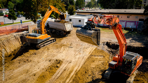 Ariel view excavator is loading a truck with ground on building site photo