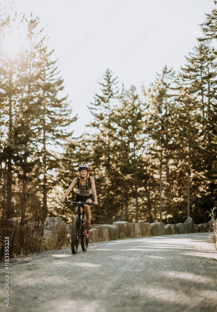 Woman cycles along dirt path in Acadia National Park, Maine Woman cycles along dirt path in Acadia National Park, Maine