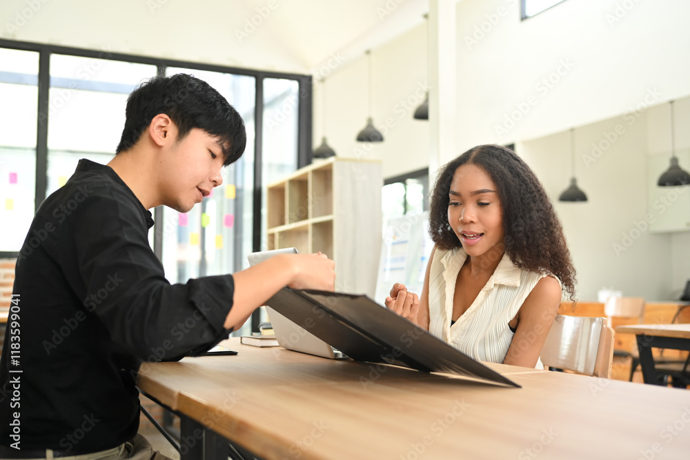 Young businesspeople collaborating in a stylish open office space. Young businesspeople collaborating in a stylish open office space.