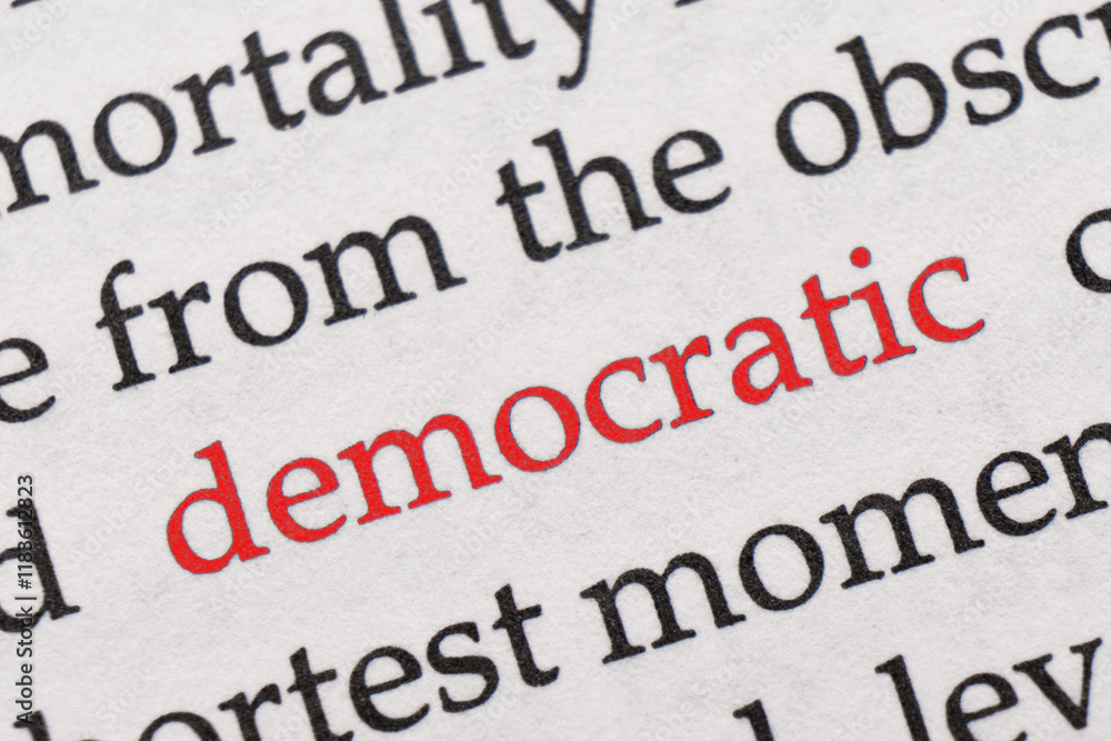 Fototapeta premium Focus on the red word Democratic. Macro shot printed red colour word Democratic on a piece of paper or book